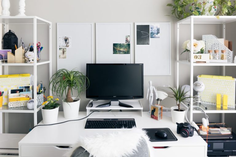 a white desk with a computer and a television on it