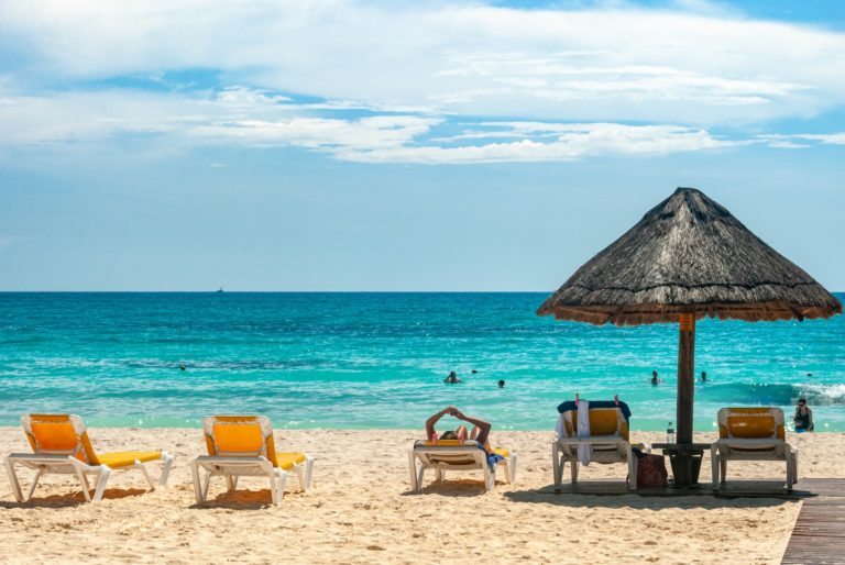 a beach with chairs and umbrellas