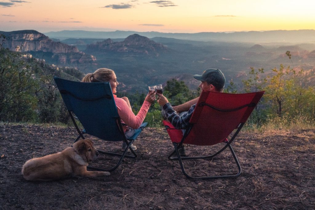 a person and a dog sitting in chairs on a beach