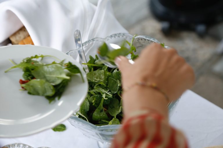 a person holding a plate of salad