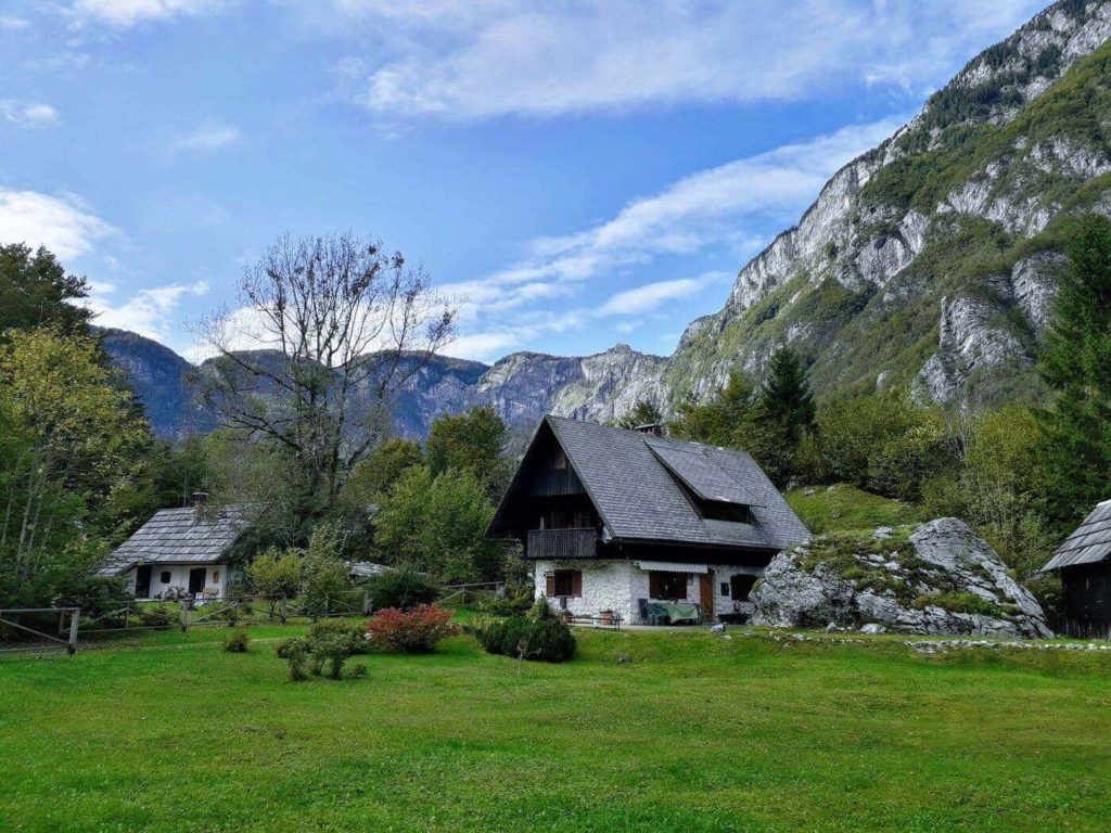 a house in a grassy area with mountains in the background