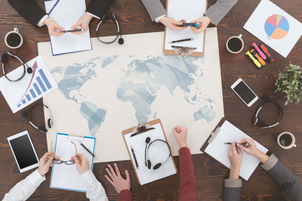 a group of people sitting around a table with papers on it